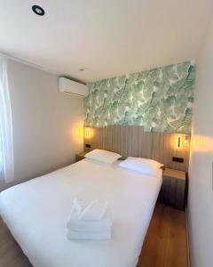 a bedroom with a large white bed with two pillows at Brit Hotel Essentiel Reims Taissy in Reims +25 photos