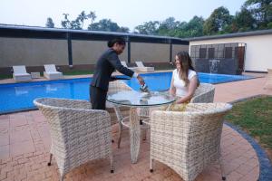 a man and a woman sitting at a glass table at B Town Resort Near Infopark Kakkanad in Kakkanad +79 photos
