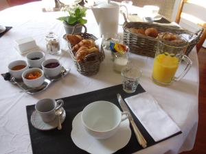 einen Frühstückstisch mit Kaffee, Croissants und Orangensaft in der Unterkunft La Pommeraie in Westrehem