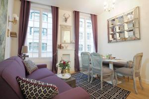 パリにあるLouvre Opera Private ChicSuitesの紫色のソファとテーブル付きのリビングルーム
