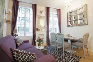 a living room with a purple couch and a table at Louvre Opera Private ChicSuites in Paris