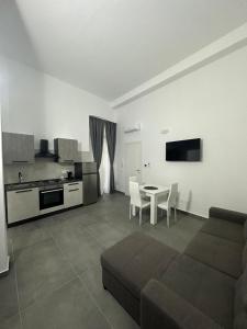 a living room with a couch and a table and a kitchen at Dimora del Corso in Caserta