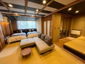 a living room with a couch and two beds at Tatsumikan in Minakami +54 photos