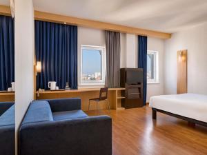 a hotel room with a bed and a couch and a desk at ibis Kyiv City Center in Kyiv +80 photos