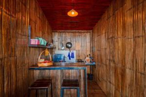 a kitchen with wooden walls and a counter with stools at Mon Ngo misty haven B1 in Ban Mae Ta Man