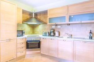 a kitchen with wooden cabinets and a stove top oven at Villa Mare, free breakfast, 80 m from sea - DIRECT LANDLORD in Hvar