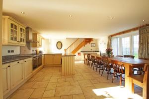 a large kitchen with a long table and chairs at Gadlas in Sarn