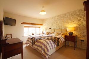 a bedroom with a bed and a stone wall at Gadlas in Sarn