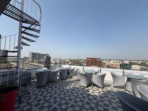 a balcony with tables and chairs on a building at Hotel Aveda Paradise in Varanasi