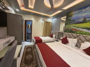 a bedroom with two beds and a painting on the wall at Hotel Aveda Paradise in Varanasi