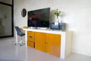 a room with a desk with a television and a chair at Best Value Room Sanur Walk to Beach - NVB in Sanur