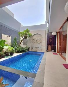 a swimming pool in the middle of a house at Best Value Room Sanur Walk to Beach - NVB in Sanur