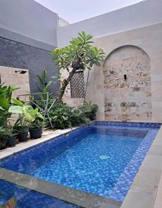 a swimming pool in the middle of a yard with plants at Best Value Room Sanur Walk to Beach - NVB in Sanur +12 photos