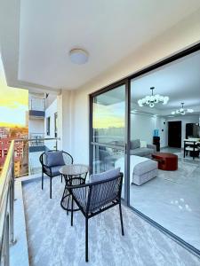 a room with a bed and a living room with a view at Pearl Luxe Homes at Orchid Residency - Spacious 2BR in Westlands With Pool, Gym, Rooftop views & breakfast café in Nairobi
