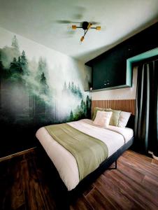 a bedroom with a large bed with a painting on the wall at L'émeraude Waulsort in Waulsort