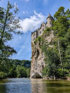 a castle on top of a rock in the water at L'émeraude Waulsort in Waulsort