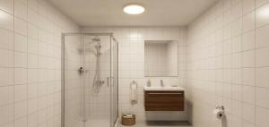 a white tiled bathroom with a shower and a sink at Kaptanlar in Side