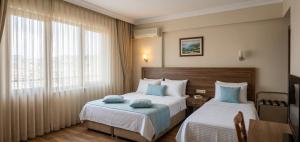 a hotel room with two beds and a window at Kaptanlar in Side +14 photos