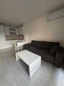 a living room with a couch and a table at White Horizon Apartment in Teslić