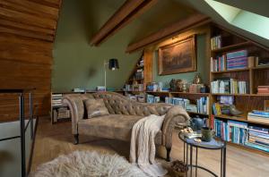 a living room with a couch and book shelves at PusztaFarm - Boutique Retreat with Wellness 6 to 8 Guests in Fülöpháza