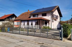 a house with a fence and a solar roof at Studio Apartman Grgurić in Karlovac