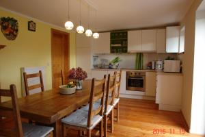 - une cuisine avec une table à manger en bois et des chaises dans l'établissement La Petite Maison, à Sart lez Walhain