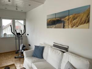 a living room with a white couch and a painting at Altrhein Hideaway ruhige Ferienwohnung nahe Frankfurt ideal für Natur & Radfahrer in Riedstadt