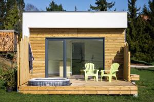 a cabin with two chairs and a table on a deck at Lodge Romy in Schalkendorf