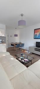 a living room with couches and a table and a tv at Juliusruh Strandparadies 3 in Juliusruh