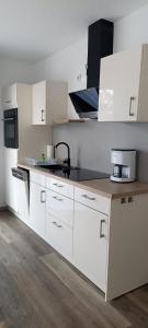 a kitchen with white cabinets and a counter top at Juliusruh Strandparadies 3 in Juliusruh +7 photos
