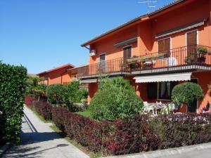 ラツィーゼにあるAppartamento Da Elenaのバルコニーといくつかの茂みのあるオレンジ色の建物