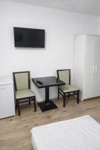 a room with a table and two chairs and a television at Monteurzimmer deSoL in Forst
