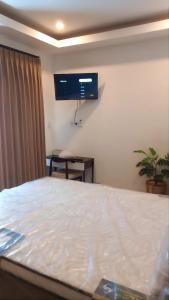 a bedroom with a bed and a tv on the wall at Papayas 2 Villa in Yogyakarta