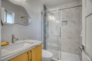 a white bathroom with a sink and a shower at Modern Luxury Sierra Lodge | 3BR, 3BA | Hotel Vibe in Groveland +15 photos