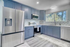 a kitchen with blue cabinets and a white refrigerator at Modern Luxury Sierra Lodge | 3BR, 3BA | Hotel Vibe in Groveland
