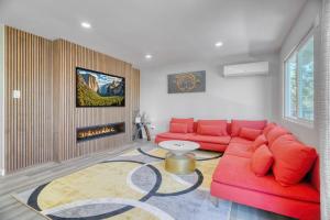 a living room with a red couch and a fireplace at Modern Luxury Sierra Lodge | 3BR, 3BA | Hotel Vibe in Groveland