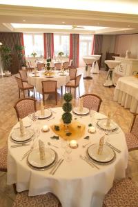 uma sala de jantar com mesas e cadeiras brancas em Hotel Pfeffermühle em Borchen