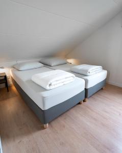 a bedroom with two beds with white sheets and pillows at Spaanse Galeien 16 in Retranchement