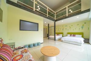 a bedroom with two beds and a tv on the wall at 窩心の家民宿 in Suao