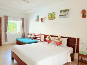 a bedroom with a large white bed with flowers on it at Palma Resort Phu Quoc, Trademark Collection by Wyndham in Phú Quốc