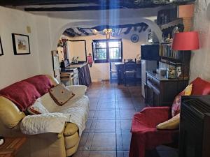 a living room with a couch and a kitchen at Casita Tomate in Granada