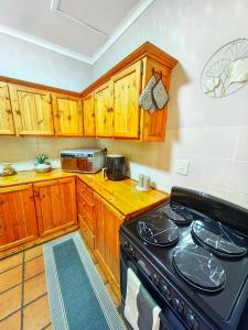a kitchen with wooden cabinets and a stove top oven at Meya B in Harrismith +13 photos