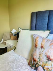 a bed with a blue headboard and a pillow on it at Meya B in Harrismith