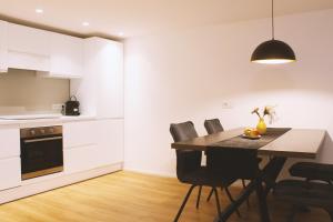 a kitchen and dining room with a table and chairs at Apartment TrentaTre in Chiusa +12 photos