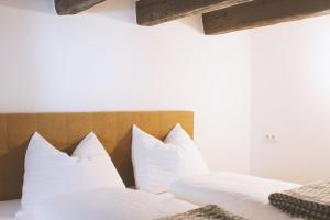a bedroom with two beds with white pillows at Apartment TrentaTre in Chiusa