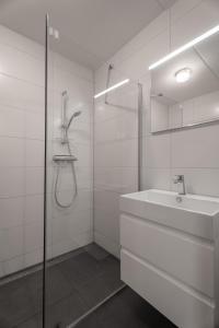 a white bathroom with a sink and a shower at Spaanse Galeien 16 in Retranchement