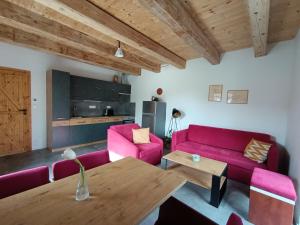 a living room with pink furniture and a wooden table at Otava apartments - Rezidence Valcha in Sušice