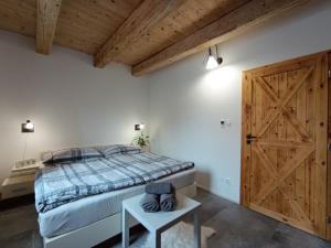 a bedroom with a bed and a wooden door at Otava apartments - Rezidence Valcha in Sušice