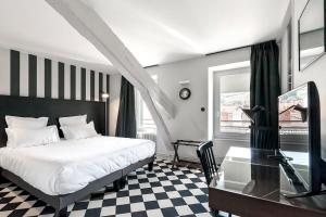 a bedroom with a bed and a desk and a glass table at Urban Style Hotel des Carmes in Aurillac