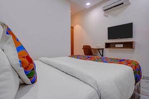 a bedroom with a bed and a tv on a wall at FabHotel Beverly Plaza in Mumbai